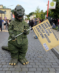 Demonstration "Wer hat der gibt" in Hamburg Blankenese am 21.08.21; Dinosaurier mit Fahne - Wir können uns die Reichen nicht mehr leisten.