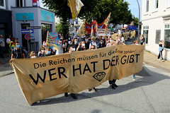 Demonstration "Wer hat der gibt" in Hamburg Blankenese am 21.08.21; Transparent - Die Reichen müssen für die Krise zahlen - WER HAT DER GIBT.