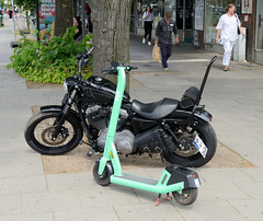 Fotos aus dem Hamburger Stadtteil Sankt Pauli, Bezirk Hamburg Mitte; Motorrad Harley-Davidson, Elektroroller am Straßenrand.