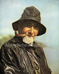 Historisches Portrait eines Finkenwerder Fischers  mit Ölzeug, Bart und Pfeife.