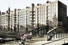 Historische Ansicht der der Hamburger Speicherstadt, ca. 1935 - Pferdefuhrwerk mit säckebeladener Anhänger und Handkarren auf der Poggenmühlbrücke, am Kanal der Zollzaun / die Grenze des Hamburger Freihafens.