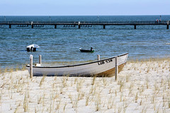 Lubmin ist ein Ort und gleichnamige Gemeinde im Landkreis Vorpommern-Greifswald im Bundesland Mecklenburg-Vorpommern;  Boot am Strand - im Hintergrund die Seebrücke.