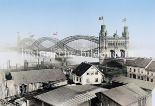 Alte Ansicht der Elbbrücke über die Norderelbe ca. 1891 - die Straßenbrücke wurde 1887 fertiggestellt; im Vordergrund ein Holzlager und Gebäude auf der Veddel, am Elbufer ein Schiffsanleger mit Wasserbrücke.