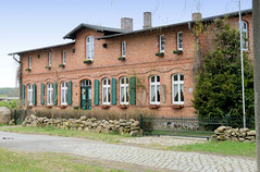 Jasnitz ist ein Ortsteil der Gemeinde Pcher im Landkreis Ludwigslust-Parchim in Mecklenburg-Vorpommern; Wohnhaus mit Fensterläden, Steinmauer.