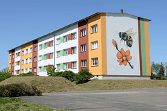 Wittenförden ist eine Gemeinde im Landkreis Ludwigslust-Parchim in Mecklenburg-Vorpommern; farbiger Wohnblock mit Fassadenmalerei, Biene / Blüte.