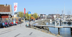 Heiligenhafen ist eine Kleinstadt im Kreis Ostholstein, Schleswig-Holstein;  Promenade an der Marina - Sitzbänke und Restaurants.