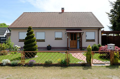 Fotos aus Neustadt-Glewe im Landkreis Ludwigslust-Parchim in Mecklenburg-Vorpommern; Einzelhaus mit spiralförmig geschnittenen Buchsbaum.