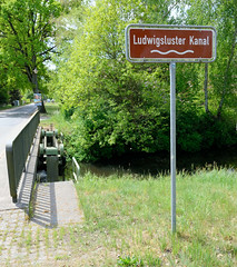 Lauf des Ludwigsluster Kanals im Dorf Tuckhude, Neustadt-Glewe; Namensschild an der Brücke.