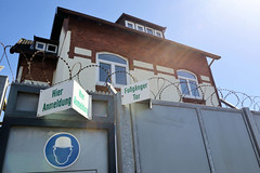 Fotos aus dem Hamburger Stadtteil Veddel, Bezirk Hamburg Mitte; Zaun mit Stacheldraht, Fußgängertor in der Peutestraße.
