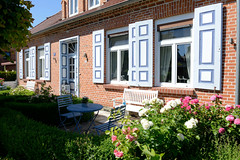 Dändorf   ist ein Ortsteil der Gemeinde Ostseebad  Dierhagen  im Landkreis Vorpommern-Rügen im Bundesland Mecklenburg-Vorpommern; Wohnhaus mit farblich abgesetzten Fensterluken - blühende Blumen.