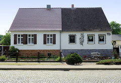 Birkholz ist eine Ortschaft und ein Ortsteil der Stadt Tangerhütte im  Landkreis Stendal in Sachsen-Anhalt; Doppelhaus mit unterschiedlicher Fassadengestaltung, Vorgärten.