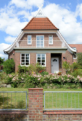 Fotos aus dem Hamburger Stadtteil Bergedorf; Einzelhaus mit Giebelschmuck, Pferdköpfe - blühende Rosen.