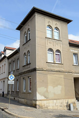 Apolda ist eine Stadt   im  Landkreis Weimarer Land  im Bundesland Thüringen; Eckgebäude mit grauem Putz - Turm mit Namensrelief.