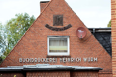 Weener ist eine Kleinstadt in Ostfriesland im Bundesland Niedersachsen; Giebel einer Druckerei mit Adler und Sinnspruch.