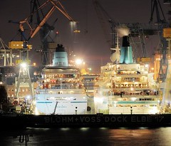 Nachtaufnahme von Kreuzfahrtschiffen im Dock der Hamburger Werft Blohm + Voss.