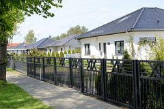 Neubau-Bungalows mit Walmdach, hoher Metallzaun an der Hauptstraße   - Fotos von Alt Zachun,  Gemeinde im Landkreis Ludwigslust-Parchim in  Mecklenburg-Vorpommern.