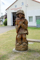 Geschnitzte Holzfigur, Feuerwehrmann mit Schlauch  - Fotos vom Seebad Zempin auf der Insel Usedom, Landkreis Vorpommern Greifswald im Bundesland Mecklenburg-Vorpommern.